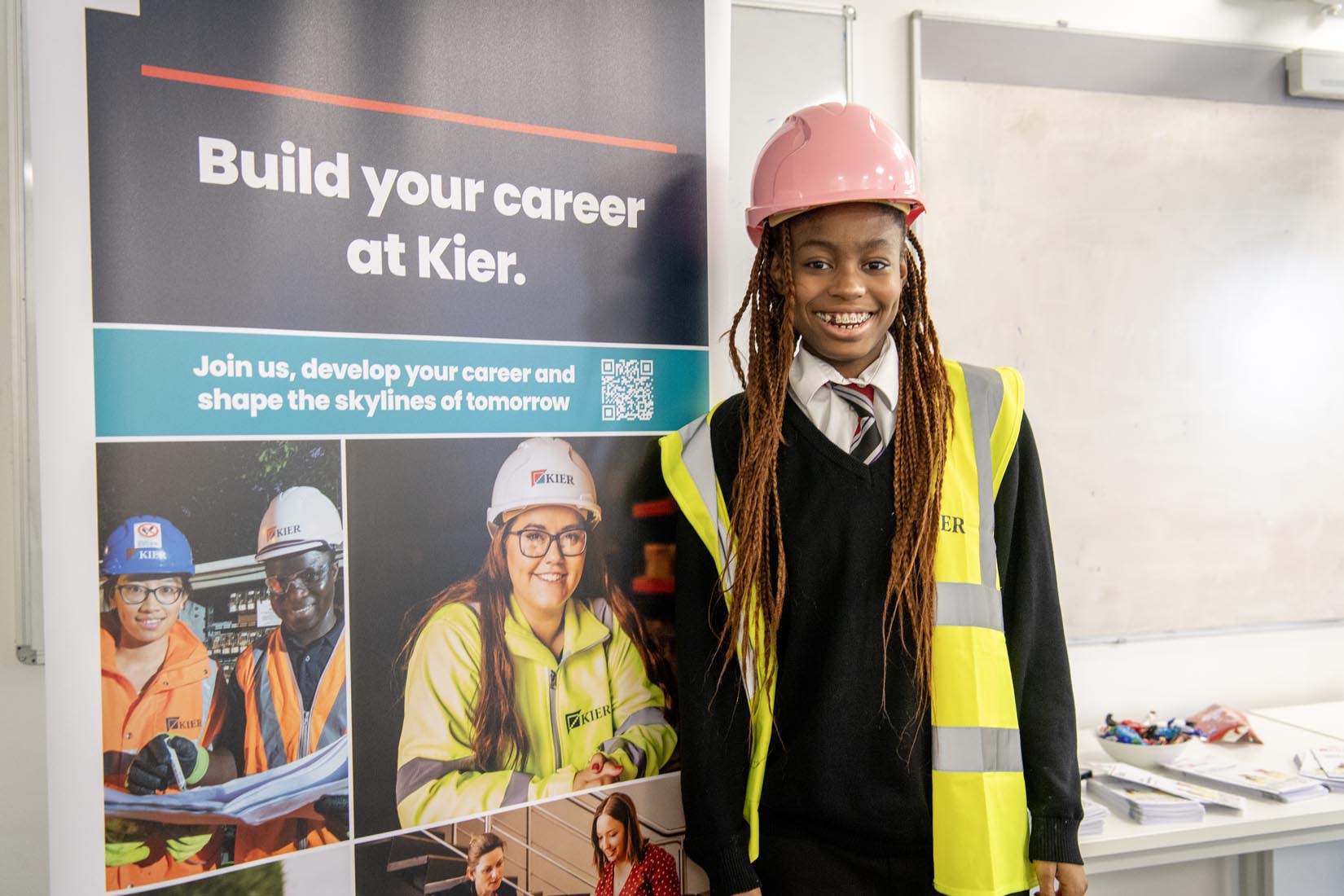 A female pupil in a hard hat and high vis jacket at Leeds College of Building